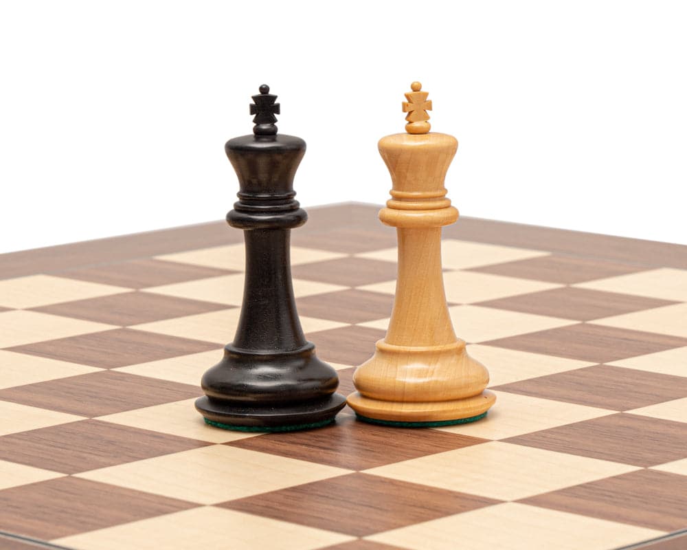 The Warwick Series 3.25 Inch Ebonised Chessmen on a chessboard - traditional Staunton design, beautifully carved and finished with superb detail