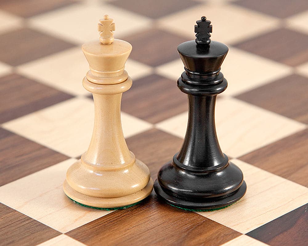 Ebonised and walnut queen chess pieces on a traditional walnut and maple chess board.