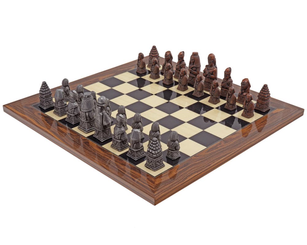 The Berkeley Chess Egyptian Metal & Palisander Chess Set on a wooden chess board with Egyptian-themed pieces.