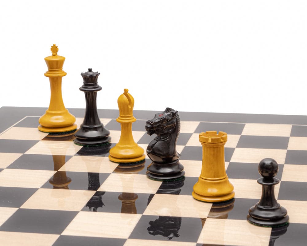 The Harrwitz Black and Anegre Staunton Chess Set with intricately carved chess pieces on a high gloss chessboard with black and maple squares.